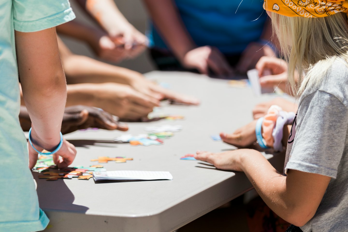 Diverse children working together on a colorful jigsaw puzzle.